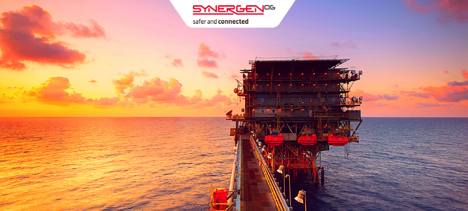 An oil platform with a bright sunset in the background.